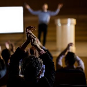 audience applauding speaker after conference presentation