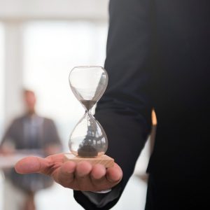businessman holding an hour glass signifies the importance of being on time