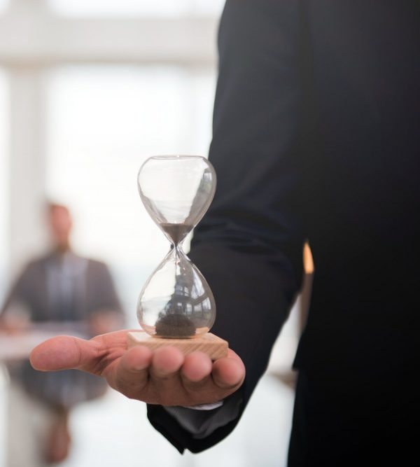 Businessman holding an hour glass, signifies the importance of being on time
