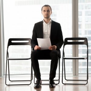 candidate on post sitting on chair with resume