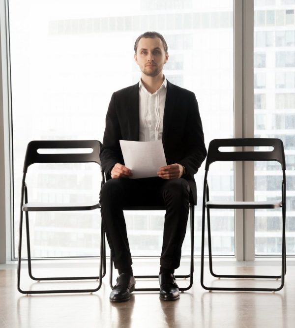 Candidate on post sitting on chair with resume